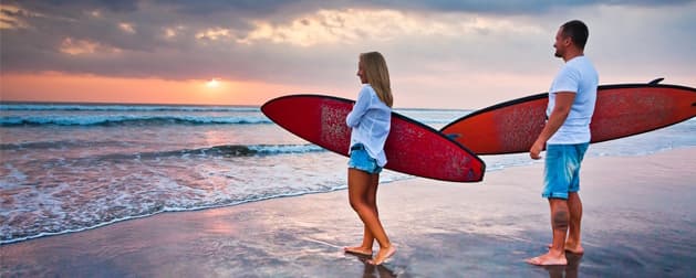 Couple with surfboards on a Bali beach